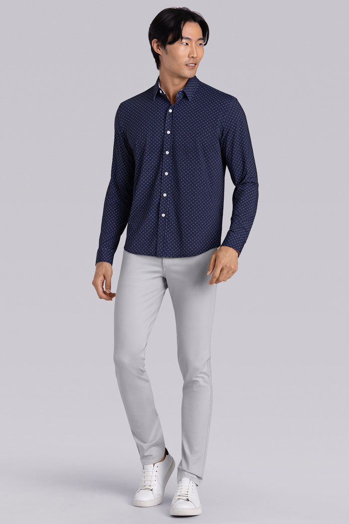 Model wearing Mesmerize Navy long sleeve dress shirt, styled with grey pants.