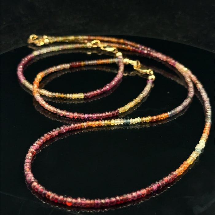 Brown sapphire necklace with matching bracelets earth tone jewelry set on a black background, front overview.