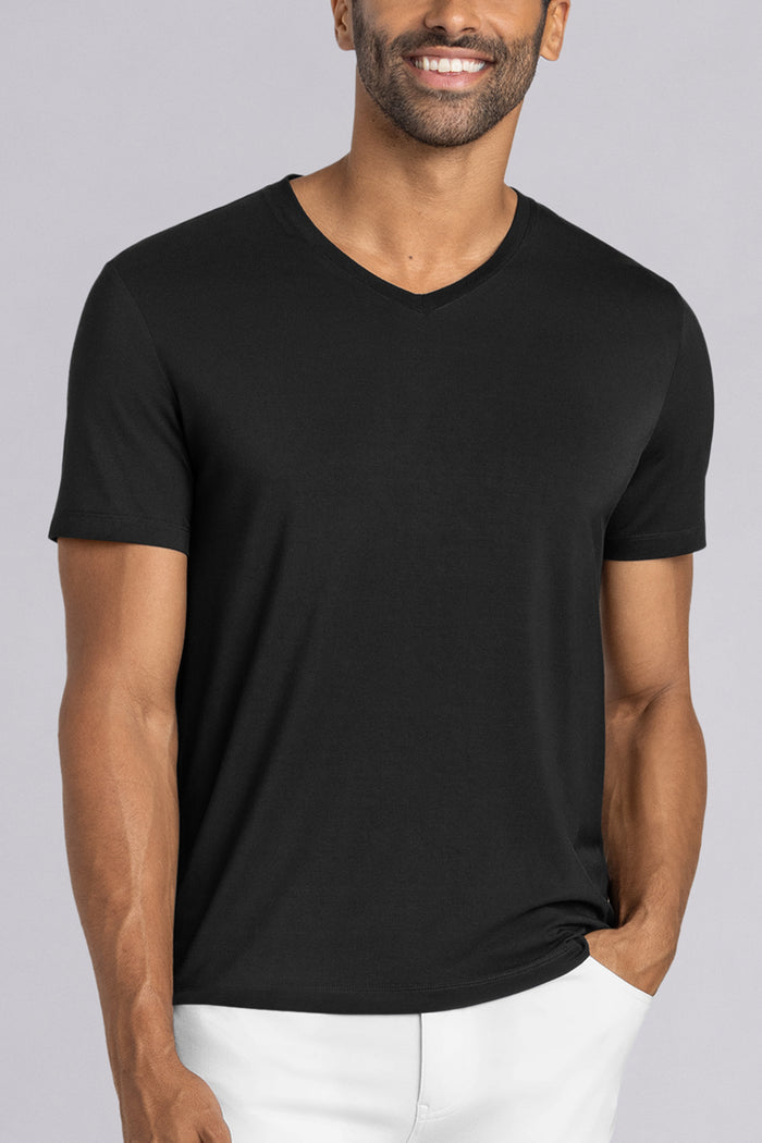 Model wearing Quintessential Black short sleeve v-neck shirt, styled with white pants