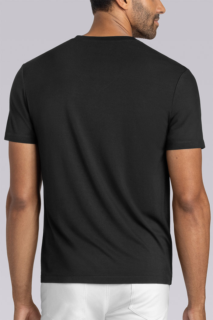 Model wearing Quintessential Black short sleeve v-neck shirt, styled with white pants