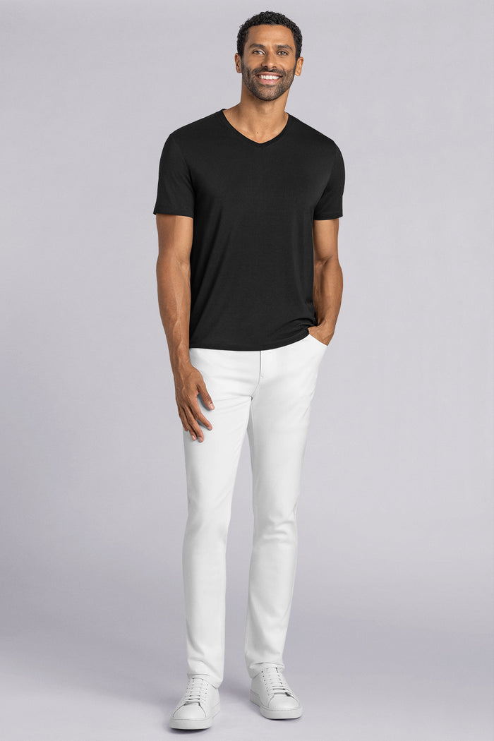 Model wearing Quintessential Black short sleeve v-neck shirt, styled with white pants