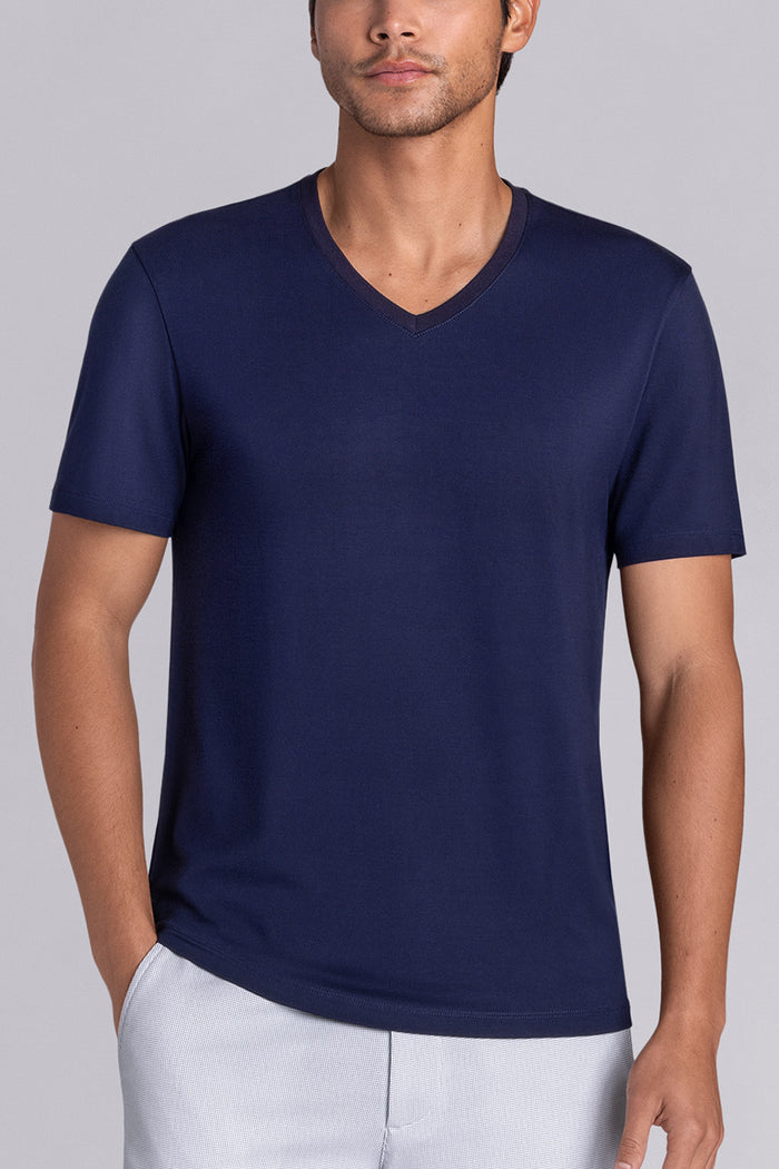 Model wearing Quintessential Monaco Blue short sleeve v-neck shirt, styled with white shorts