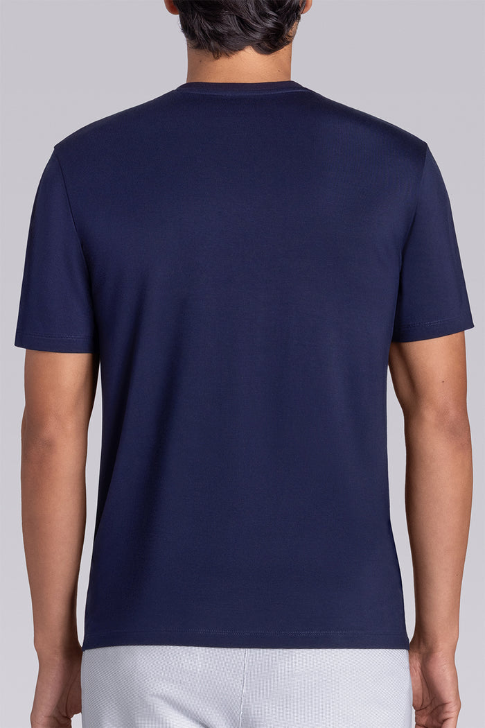 Model wearing Quintessential Monaco Blue short sleeve v-neck shirt, styled with white shorts