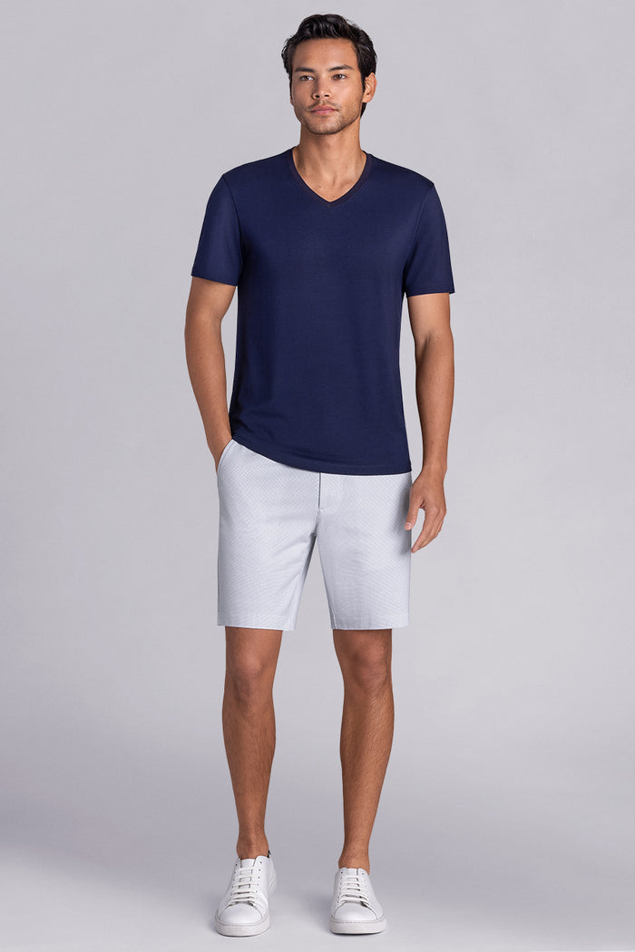 Model wearing Quintessential Monaco Blue short sleeve v-neck shirt, styled with white shorts