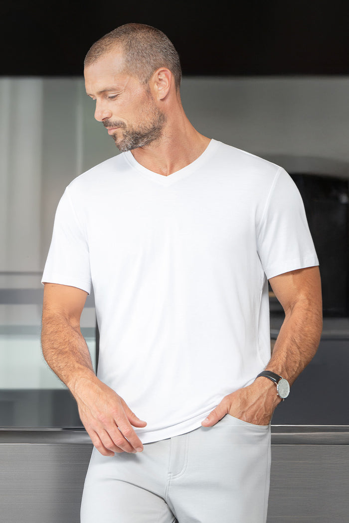 Model wearing Quintessential White short sleeve v-neck shirt, styled with grey pants