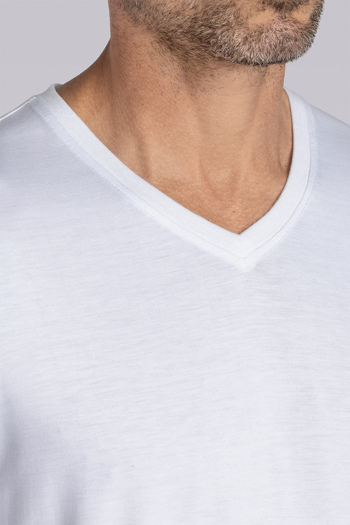 Model wearing Quintessential White short sleeve v-neck shirt, styled with grey pants