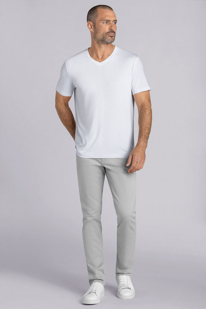 Model wearing Quintessential White short sleeve v-neck shirt, styled with grey pants