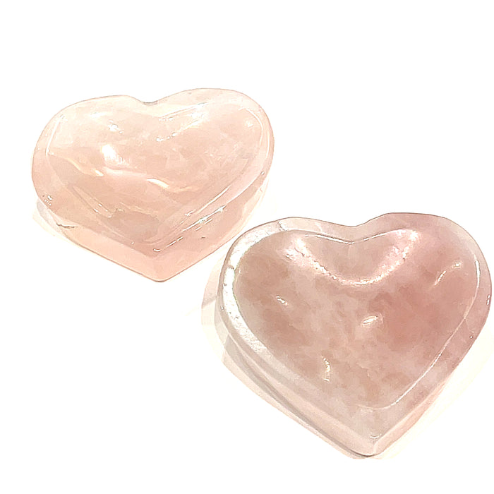 Two heart-shaped Rose Quartz gemstone bowls, one pink and one more translucent, are placed side by side, front overview on a white background.