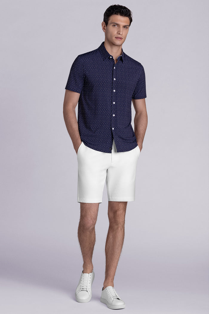 Model wearing Spirited Dark Navy short sleeve classic collar shirt, styled with white shorts