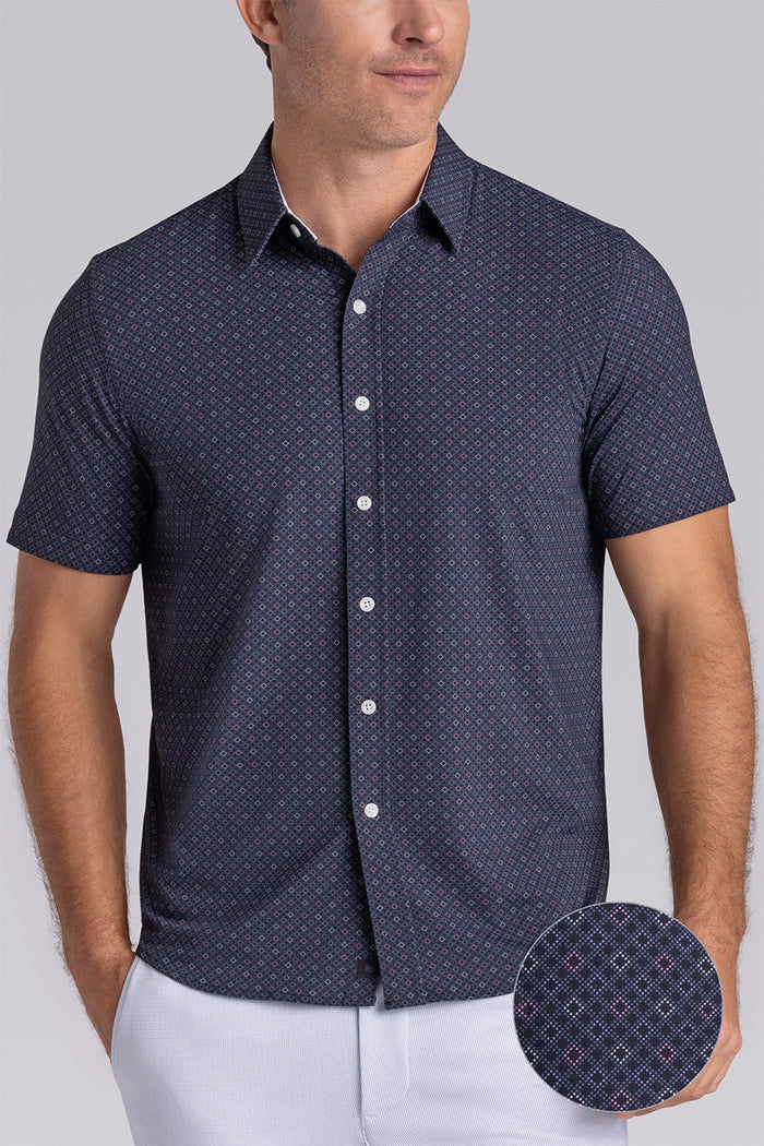 Model wearing Synergy Black Pink 6-way knit® short sleeve classic collar shirt, styled with white shorts.