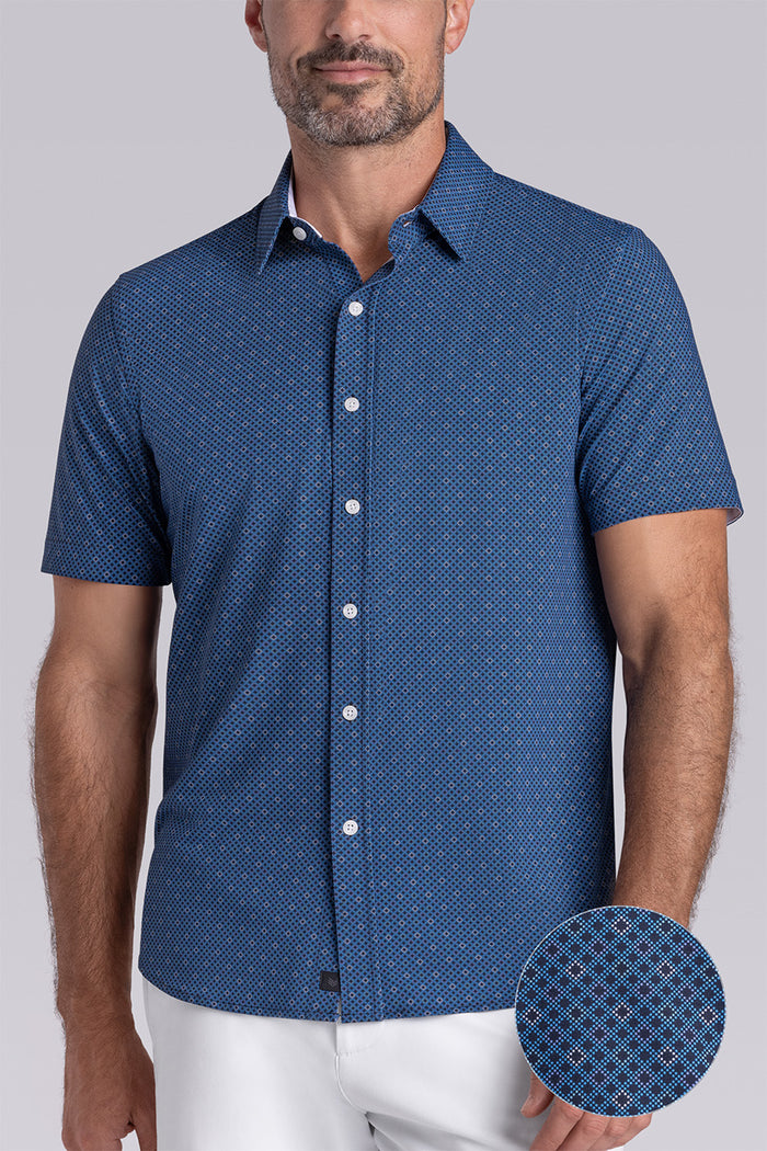Model wearing Synergy Classic Blue 6-way knit® short sleeve classic collar shirt, styled with white shorts.