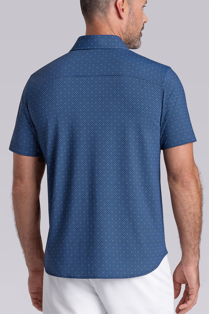 Model wearing Synergy Classic Blue 6-way knit® short sleeve classic collar shirt, styled with white shorts.