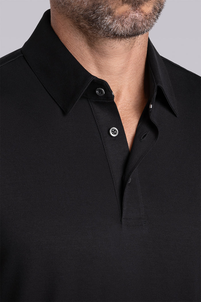 Model wearing Vital Black Icy Bamboo® short sleeve polo, styled with white pants.