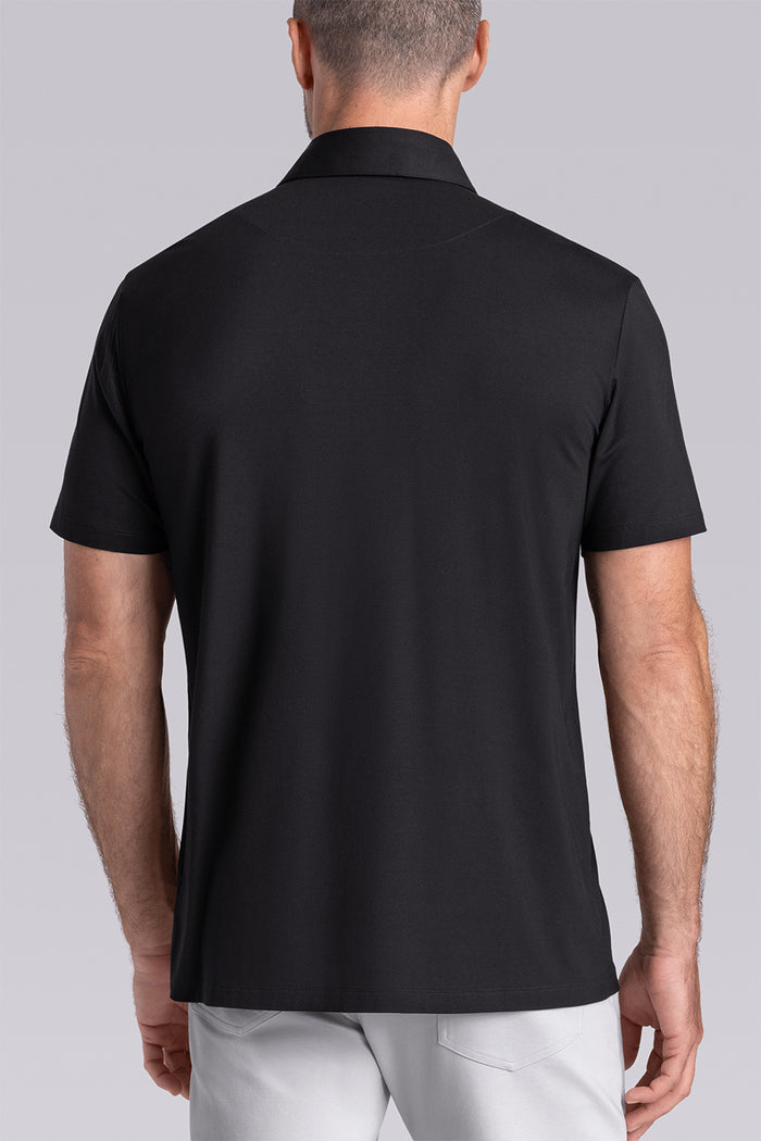 Model wearing Vital Black Icy Bamboo® short sleeve polo, styled with white pants.