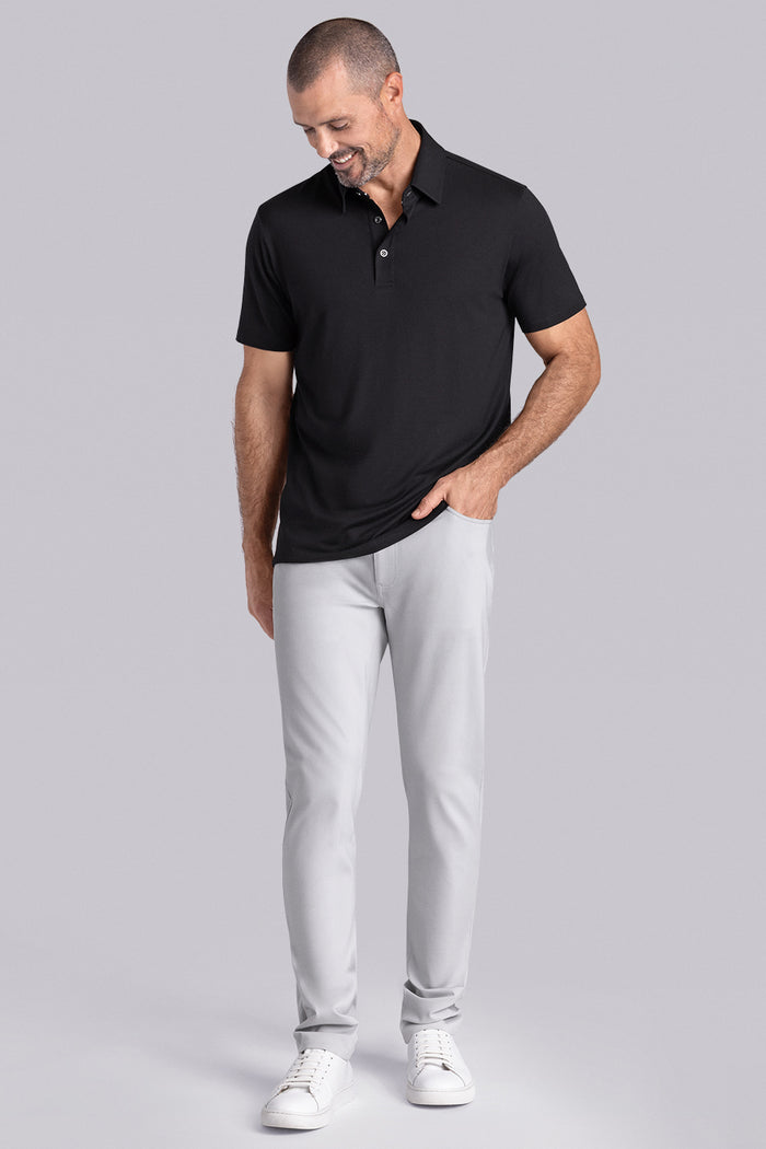 Model wearing Vital Black Icy Bamboo® short sleeve polo, styled with white pants.