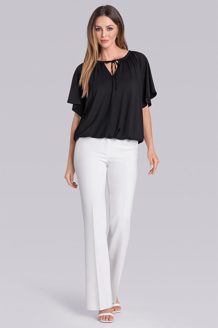 Model wearing Whisper Black Icy Bamboo® keyhole flutter sleeve tie-front, styled with white pants.