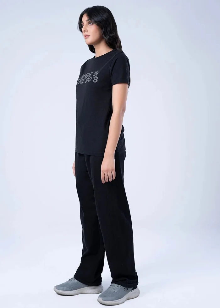 Women's black short-sleeve top, crew neck, chest graphic text; side view