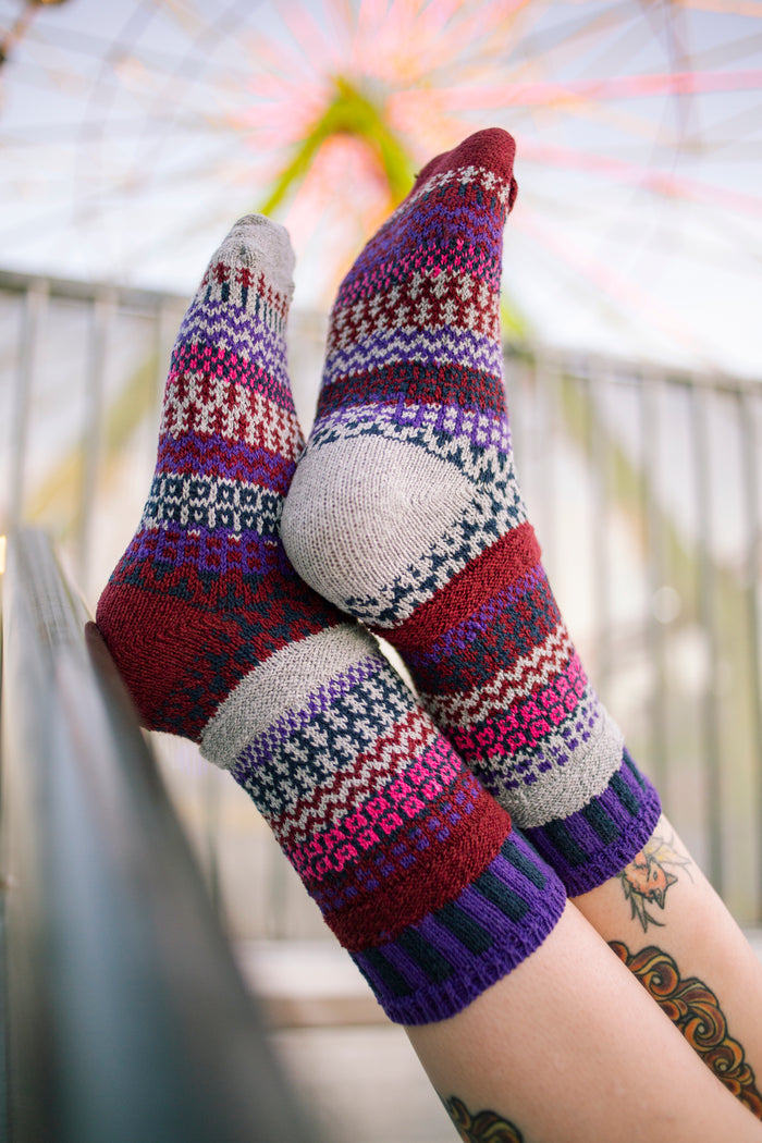 Person relaxing in Wunderland Crew Socks near a ferris wheel