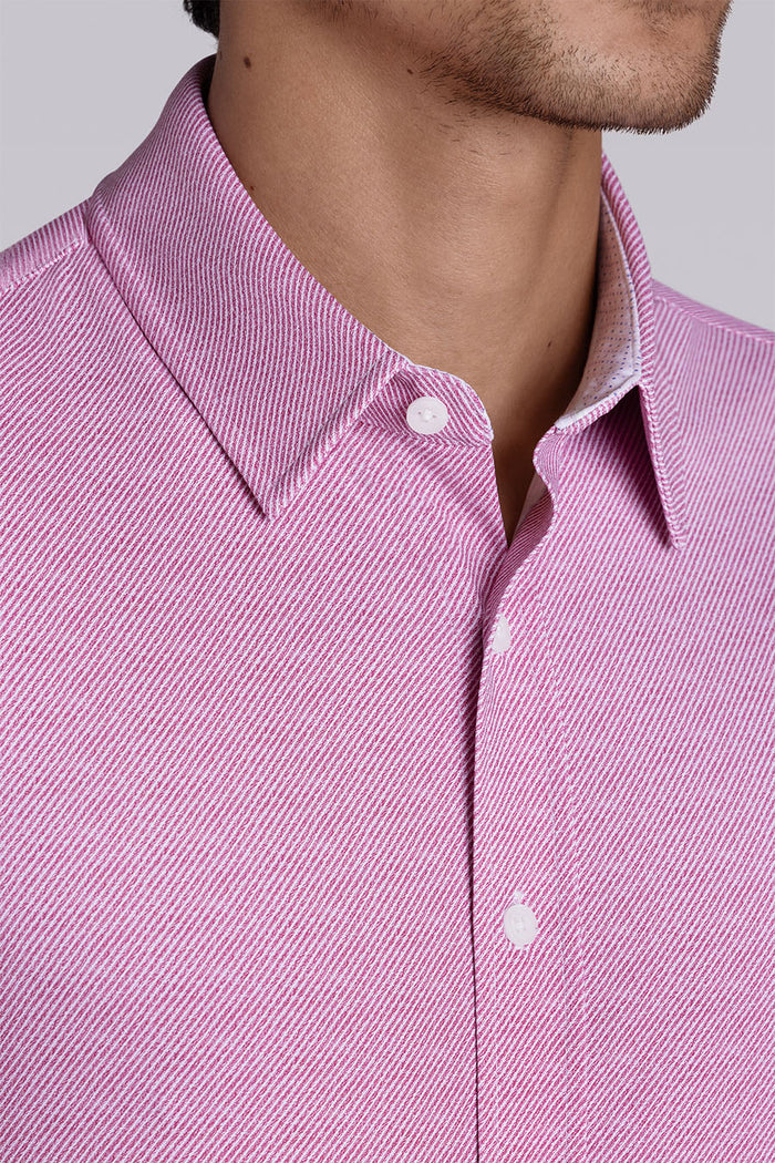 Model wearing Zest Raspberry short sleeve classic collar shirt, styled with white shorts.