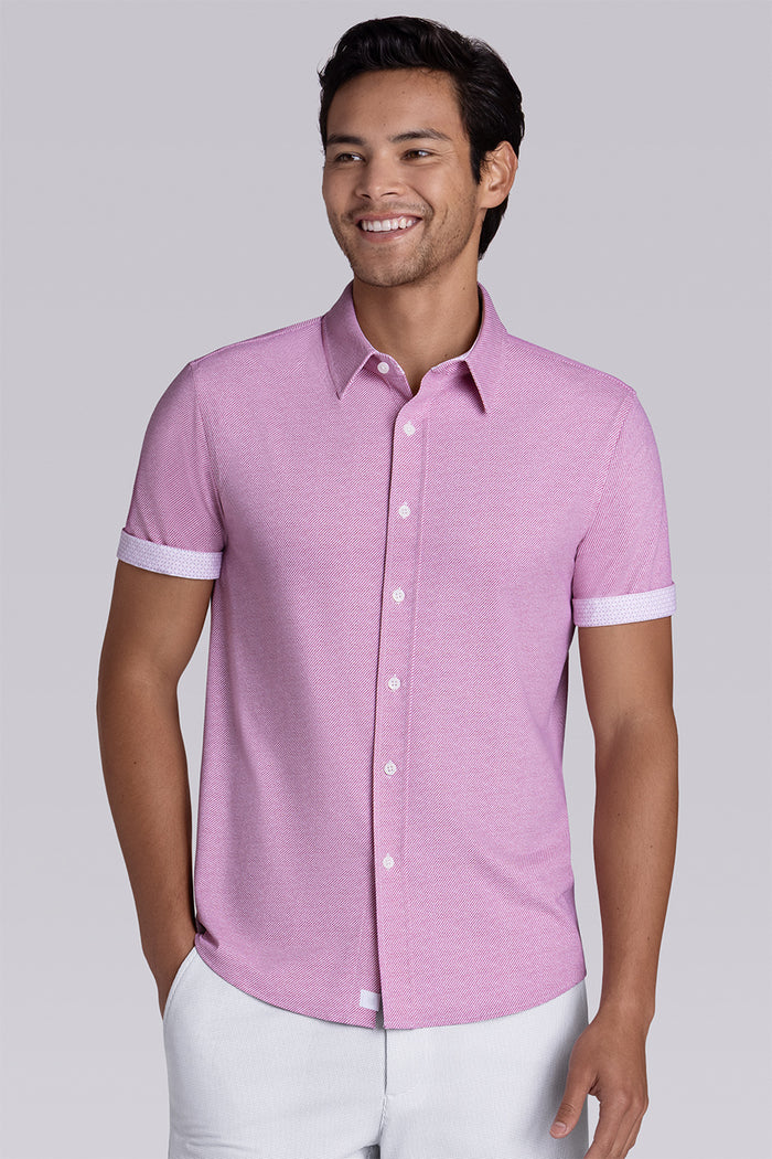 Model wearing Zest Raspberry short sleeve classic collar shirt, styled with white shorts.